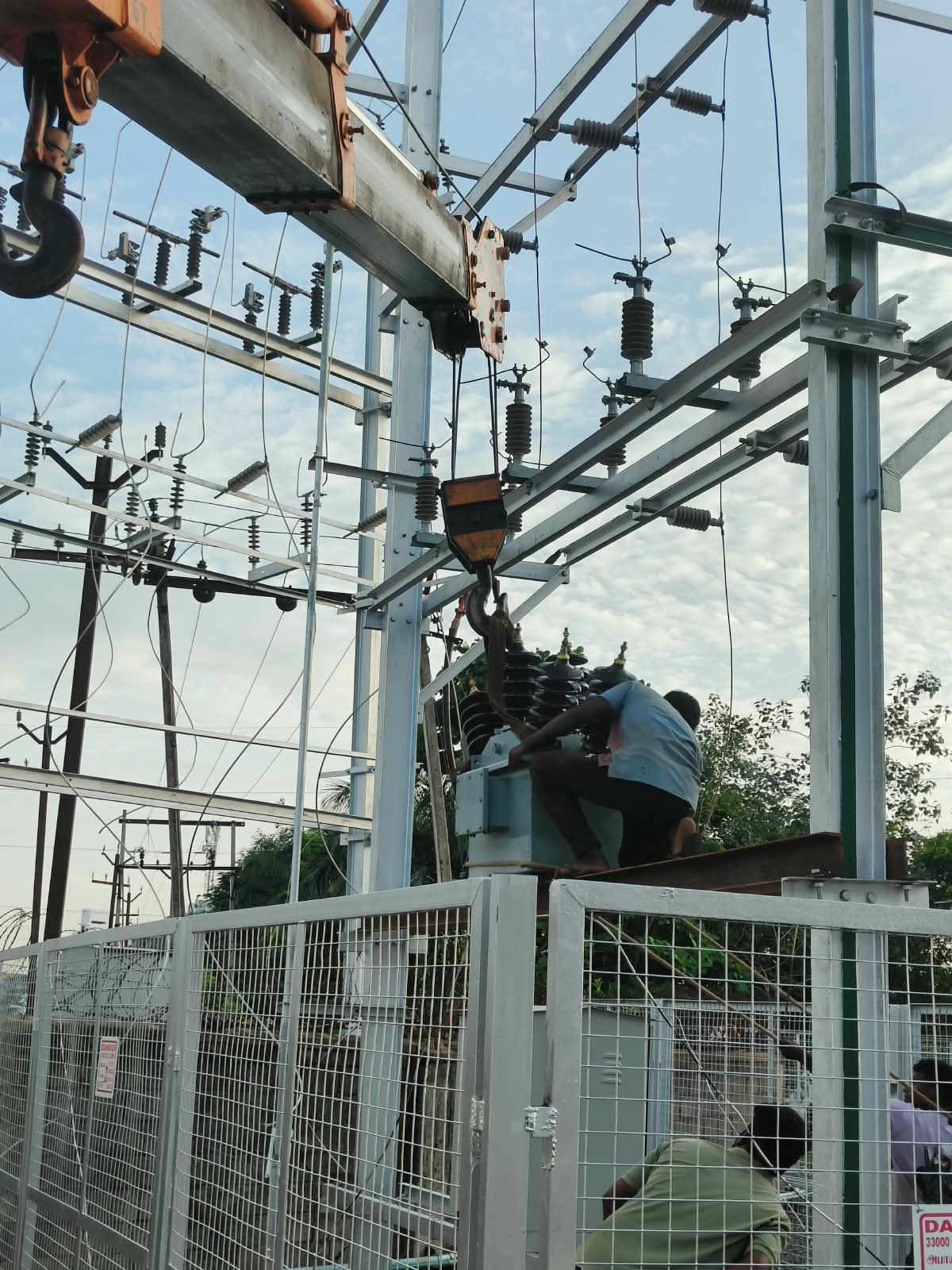 Crane lifting a power transformer into position at a 33KV switchyard